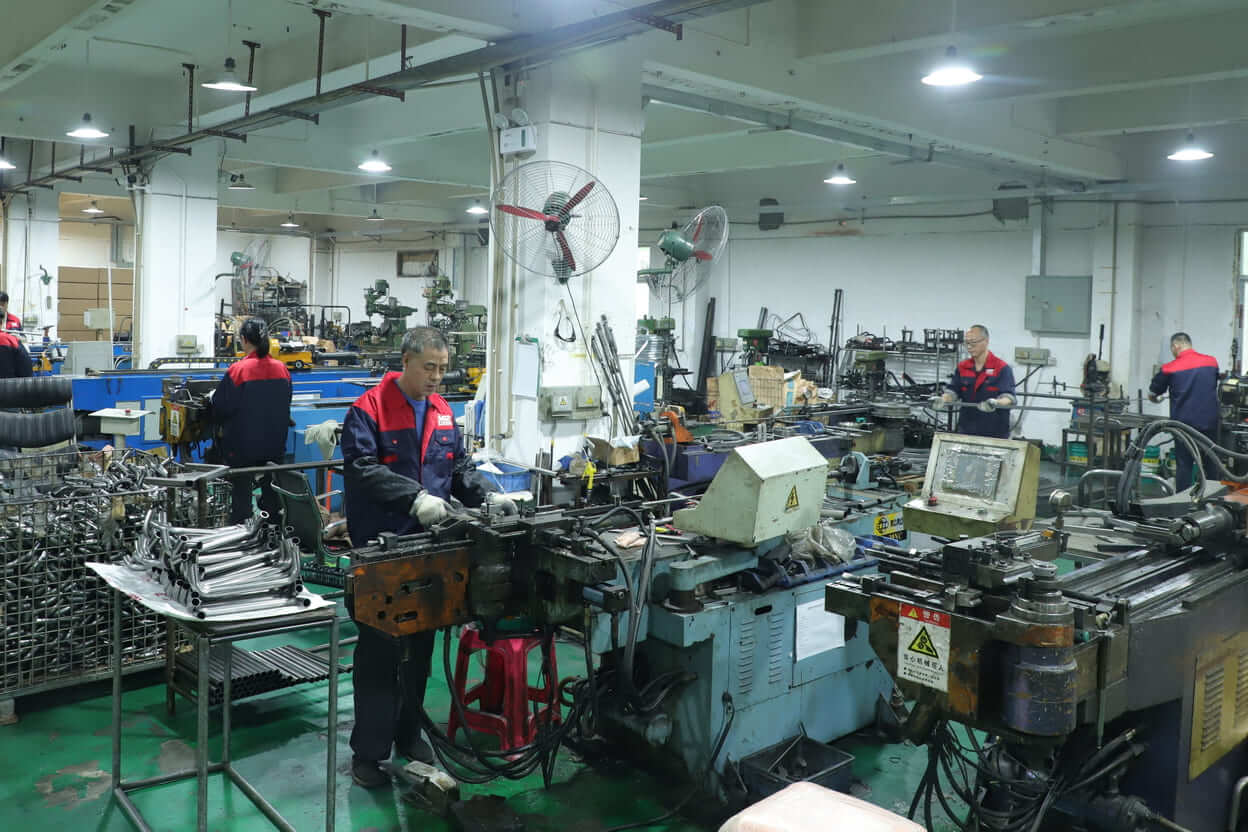 Workers operating tube bending machines in Yizhijie metal hardware workshop